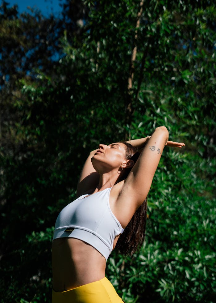 A woman in a yoga pose outdoors, symbolizing a healthy lifestyle and mindfulness.